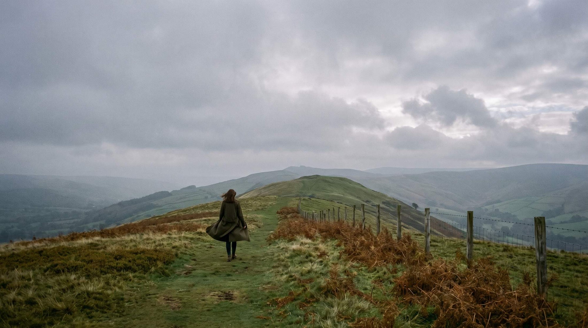 Walker in layered outerwear on a ridge path