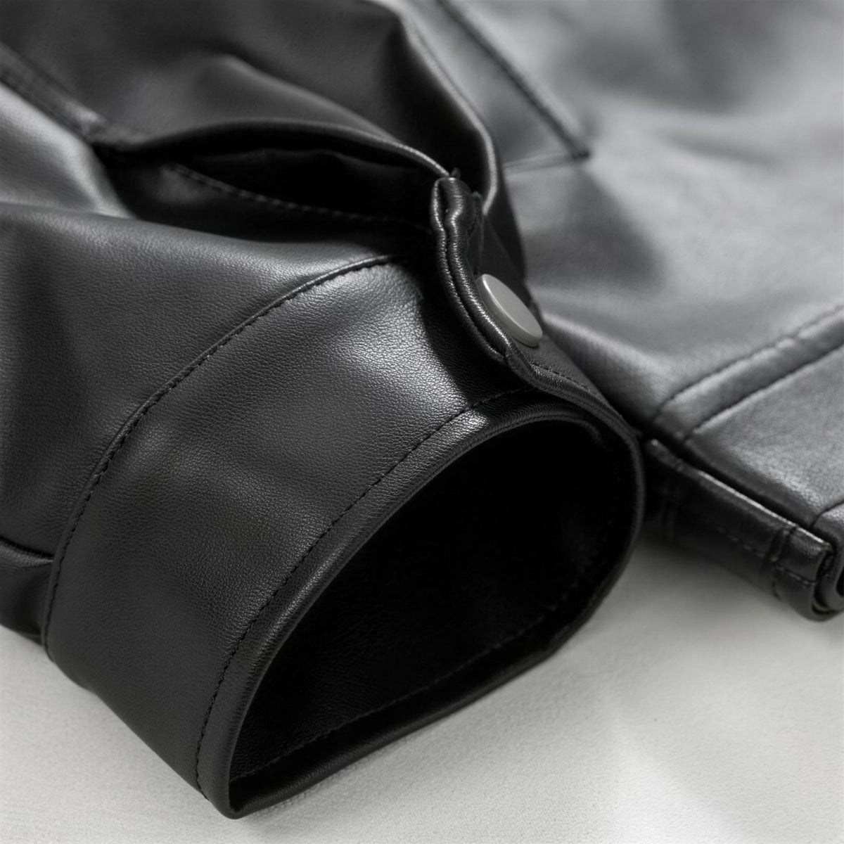 Oversized leather bomber jacket, detail of the buttoned cuff