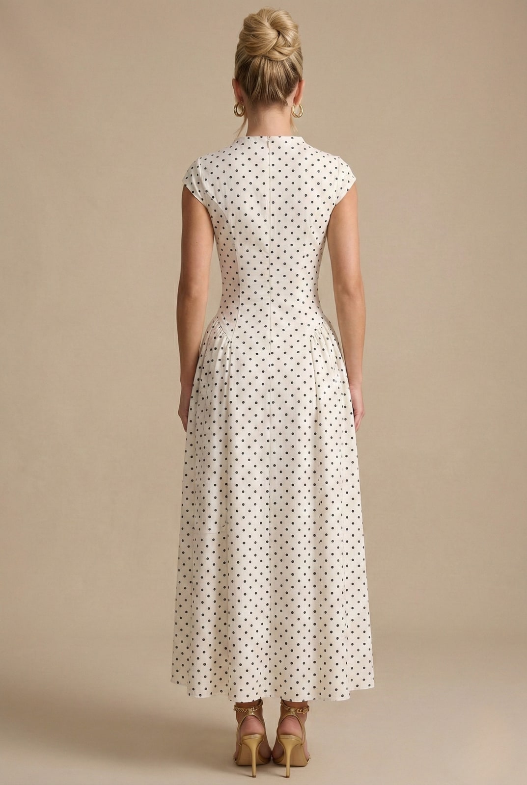 Back view of the polka dot maxi dress showing the fitted bodice and pleated skirt