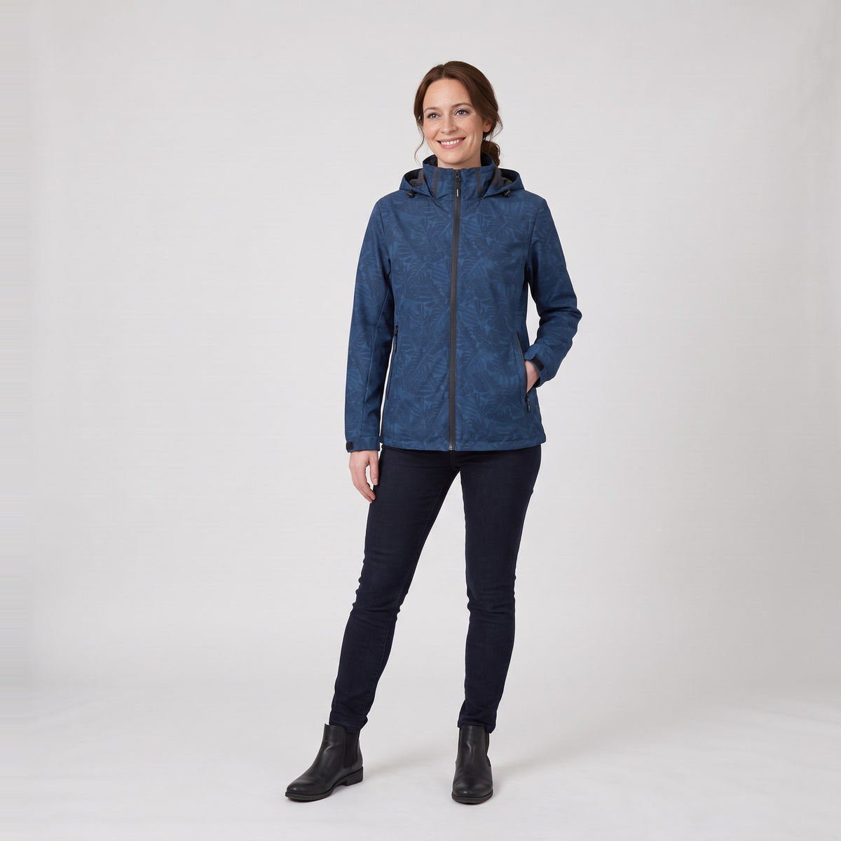 Woman wearing the leaf print hooded rain jacket with zip pockets