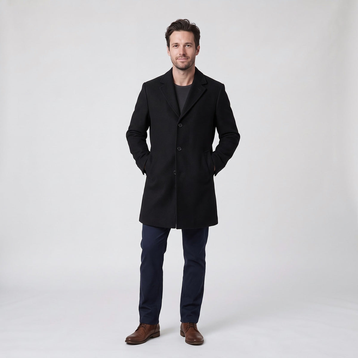 Man wearing a long black single-breasted overcoat with notch lapel and flap pockets