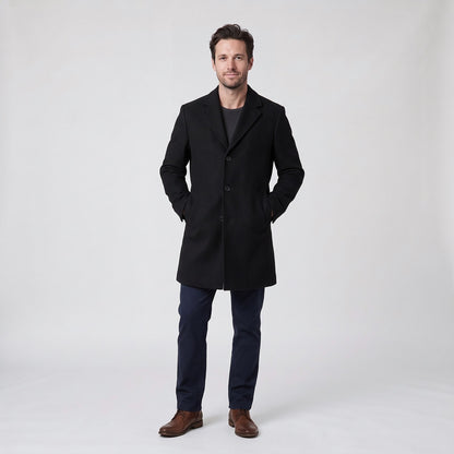 Man wearing a long black single-breasted overcoat with notch lapel and flap pockets