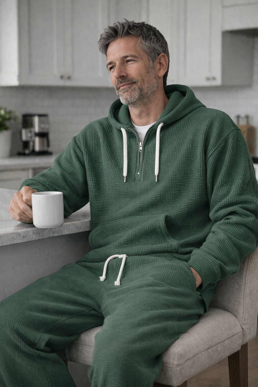 Green half zip hoodie and joggers worn indoors