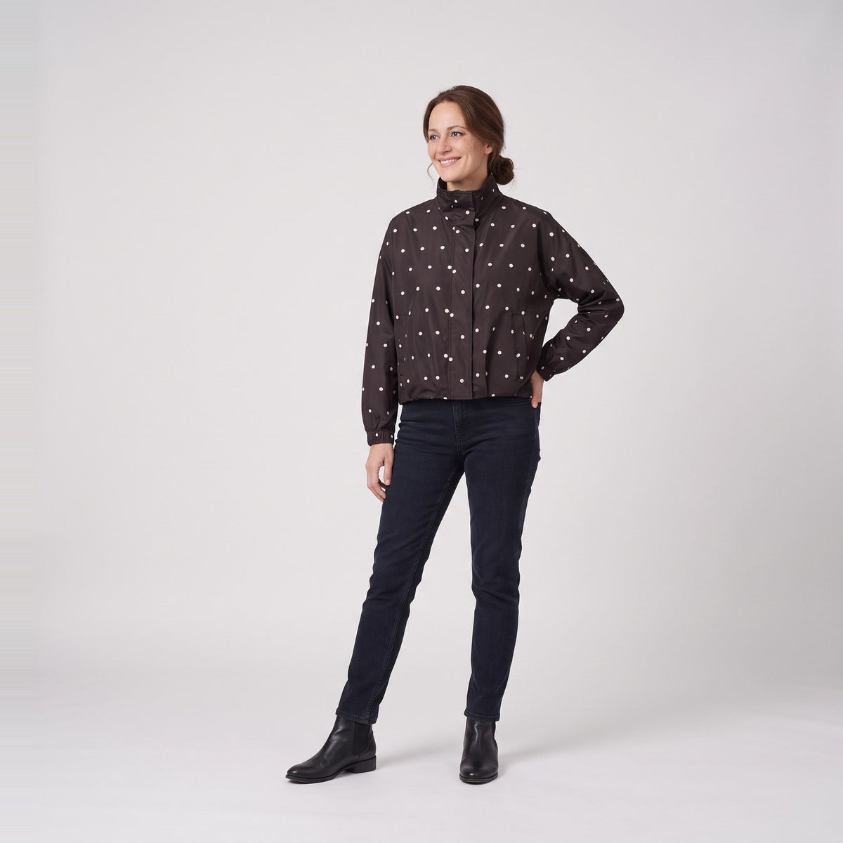 Woman wearing the polka dot bomber rain jacket with stand collar