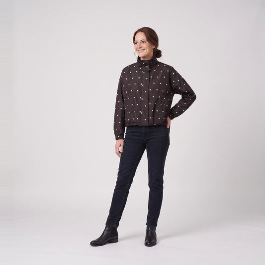 Woman wearing the polka dot bomber rain jacket with stand collar