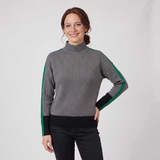 Woman wearing a grey roll neck chevron knit jumper with stripe sleeves