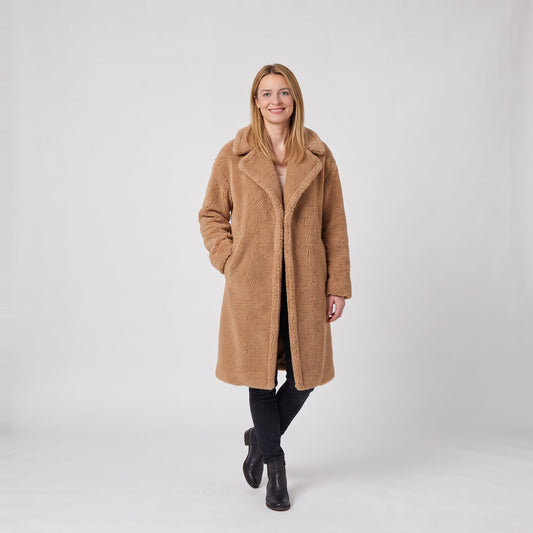 Woman wearing a camel teddy long coat in soft faux shearling